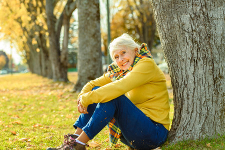 Happy elderly senior woman in an autumn park.の写真素材
