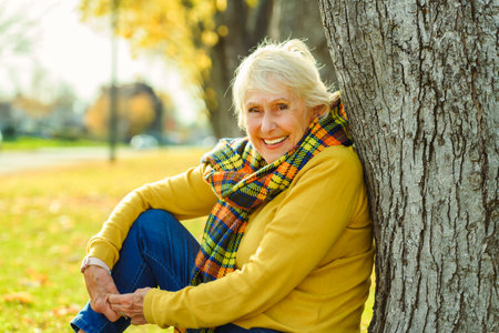 Happy elderly senior woman in an autumn park.の写真素材