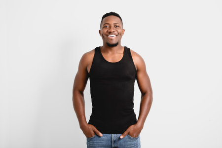 Male black wearing dark tanktop on ripped muscular torso in studio shot on white background