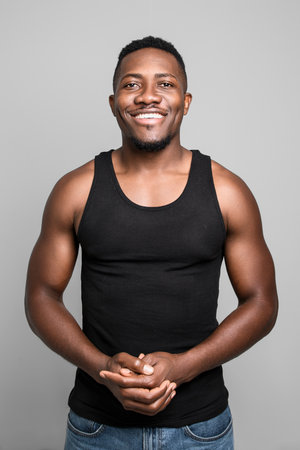 Male black wearing dark tanktop on ripped muscular torso in studio shot on white backgroundの写真素材