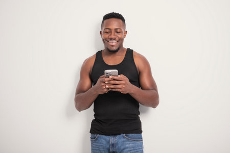 Male black wearing dark tanktop on ripped muscular torso in studio shot on white background using...