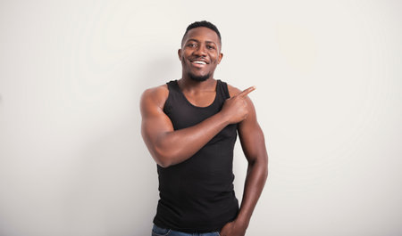 Male black wearing dark tanktop on ripped muscular torso in studio shot on white backgroundの写真素材