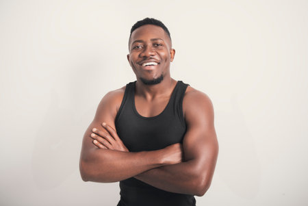 Male black wearing dark tanktop on ripped muscular torso in studio shot on white backgroundの写真素材