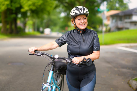 Happy mature cyclist woman enjoying healthy activityの写真素材