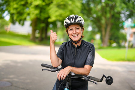 Happy mature cyclist woman enjoying healthy activityの写真素材