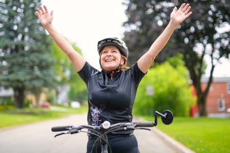 Happy mature cyclist woman enjoying healthy activityの写真素材