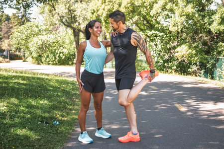 Young fitness couple running at the forest trail on a summer day