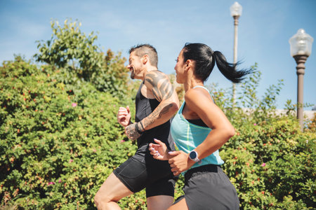 Young fitness couple running on a city on summer day