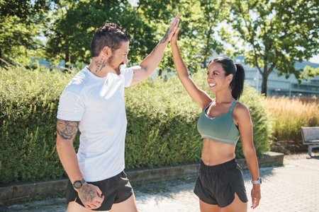 Young fitness couple running on a city street on summer day