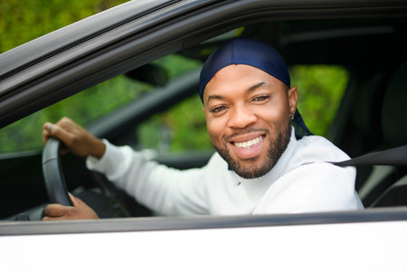 portrait of happy black american man driving car