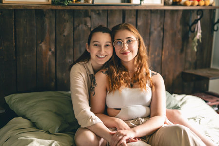 Happy couple cuddling on their bed at home. Romantic young LGBTQの写真素材