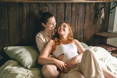 Happy couple cuddling on their bed at home. Romantic young LGBTQの写真素材