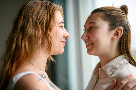 Happy couple having great time close to a window at home.