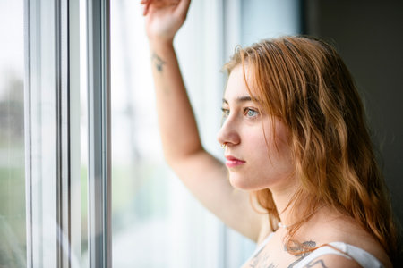 beautiful young woman in the bedroom close to a windowの写真素材
