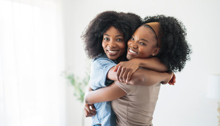 A affectionate mother and daughter sitting on sofa at homeの写真素材