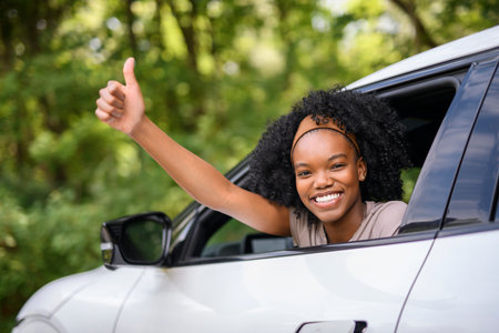Young black teenage driver in her new car