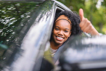 Young black teenage driver in her new car