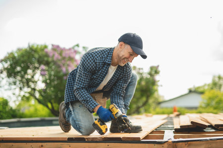 Handyman worker making patio outside close to a pool installing floor.の写真素材