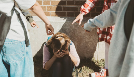 sad moment Elementary Age Bullying in Schoolyard, pointing a girlの写真素材