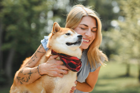 Happy woman with her dog in the forest on summer seasonの写真素材