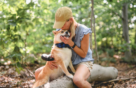 Happy woman with her Shiba Inu dog in the forest on summer seasonの写真素材