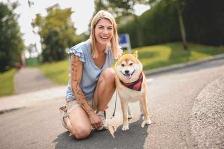 Happy woman with her dog in the park on summer seasonの写真素材