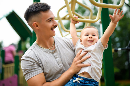 father with child boy having fun at the playgroundの写真素材