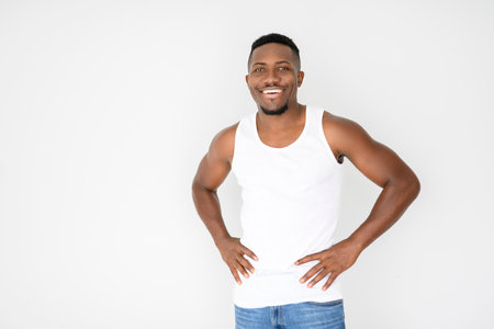 Man wearing white tanktop on ripped muscular torso in studio shot on white backgroundの写真素材