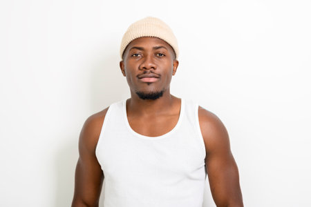 Black men wearing white tanktop on ripped muscular torso in studio shot on white background