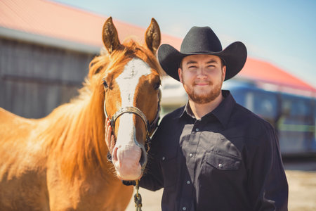 cowboy, stands next to her horse in summer seasonの写真素材