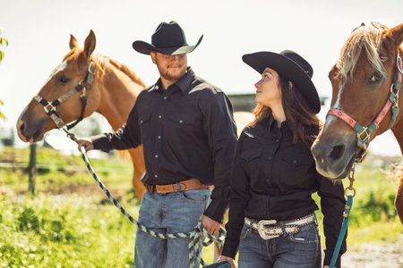 couple boy and girl, stands next to her horse in summer seasonの写真素材