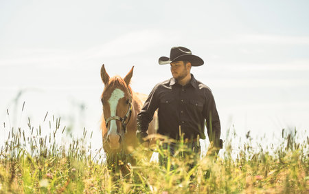 cowboy, stands next to her horse in summer season