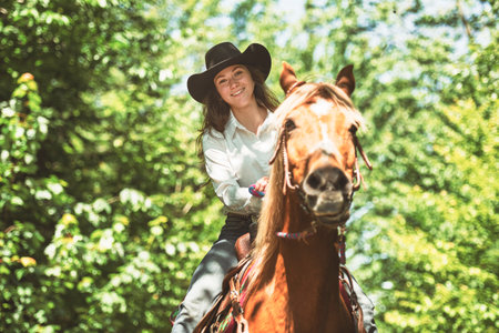 woman cowgirl, stands next to her horse in summer season
