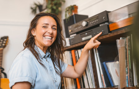 young woman putting on a vinyl record at home