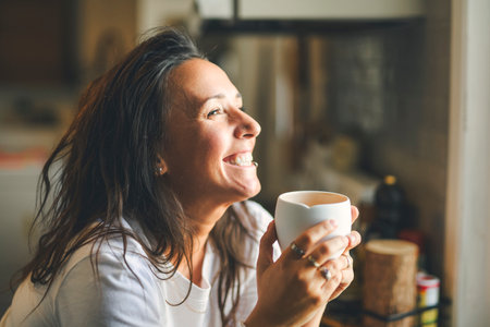 happy woman drinking coffee on the kitchen in the morning.の写真素材