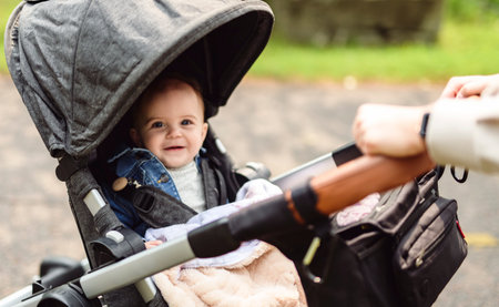 Cute healthy little beautiful baby girl sitting in strollerの写真素材