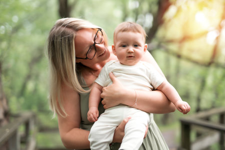 Happy family on a summer meadow. little girl child baby daughter with motherの写真素材