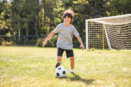 kid play football or soccer on a outdoor fieldの写真素材