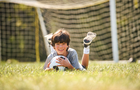 kid play football or soccer on a outdoor fieldの写真素材