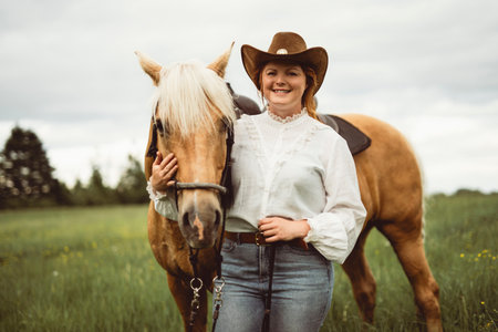 A woman is standing next to a horse in an open field