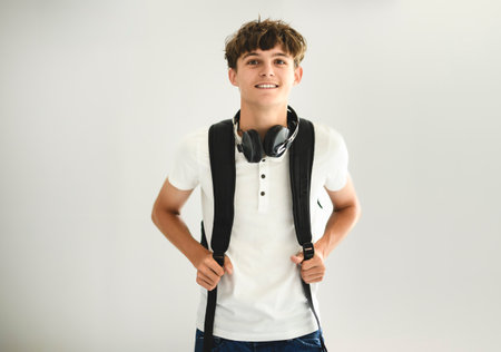 Portrait of teenage student boy in casual t-shirt on light background in studio.