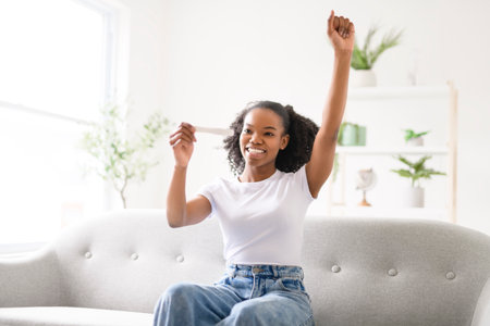 Black woman, pregnancy test and confused, nervous and waiting for results on a sofa in her homeの写真素材