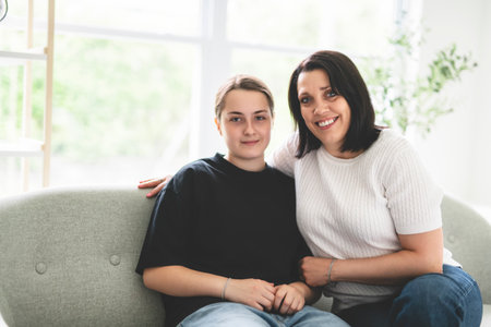 mother with teen girl, having great time on sofaの写真素材
