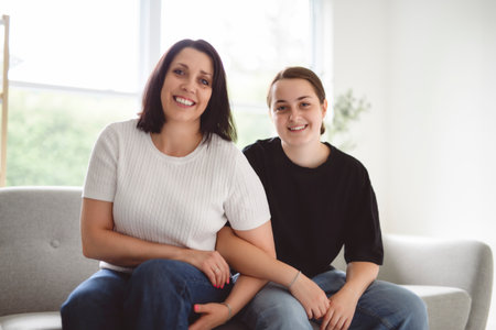 mother with teen girl, having great time on sofaの写真素材