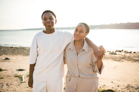 Cheerful black american mother and her son on beautiful seascapeの写真素材