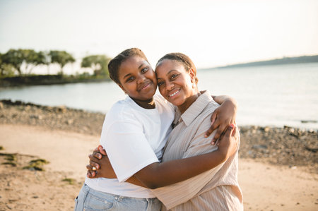 Cheerful mother and her daughter on beautiful seascapeの写真素材