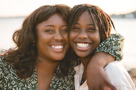 Cheerful mother and her daughter on beautiful seascape