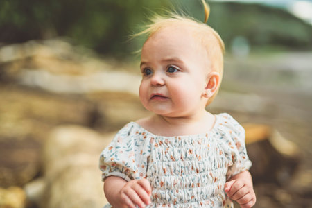 Adorable cute little baby girl on beach at the sunsetの写真素材