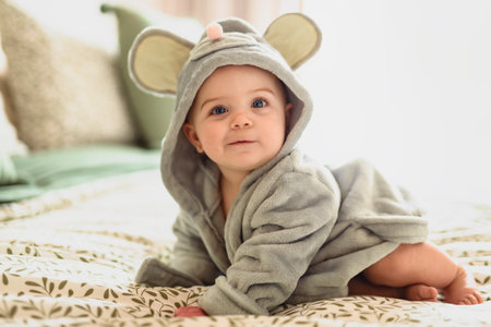 Baby girl in a Terry robe and diaper after bathing.