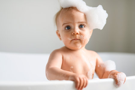 Cute little child bathing in tub at homeの写真素材